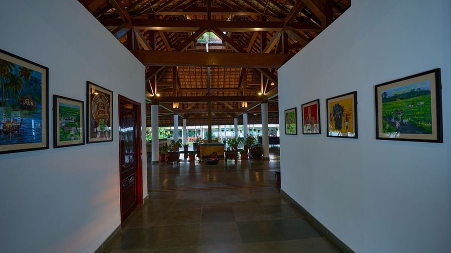 a view of the corridor with pictures hung on the wall - Rhythm Kumarakom