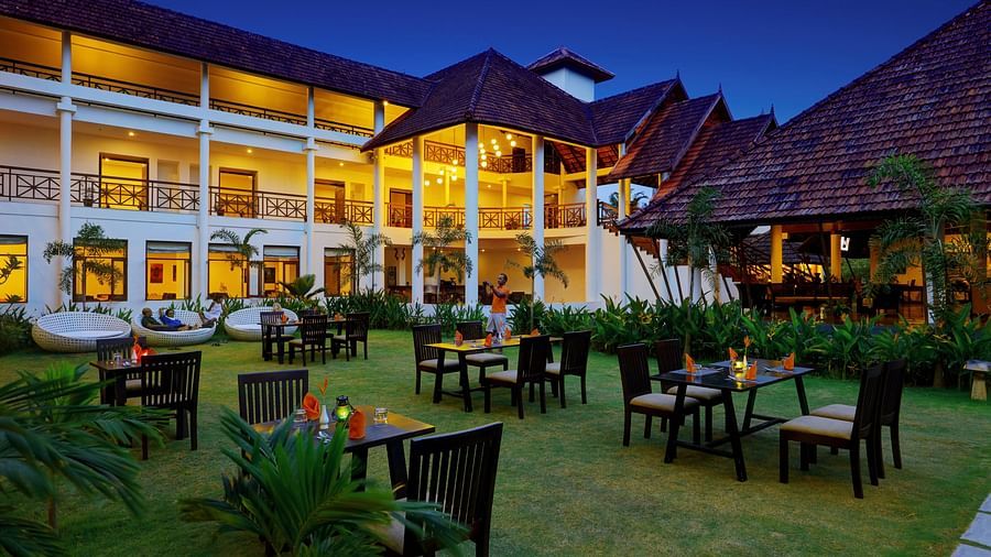 Outdoor seating in grass with Rhythm Kumarakom in the background