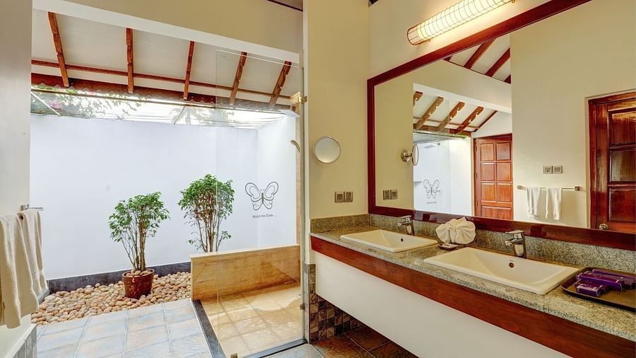 an image of an overview of the bathroom with a mirror and two sinks - Rhythm Kumarakom