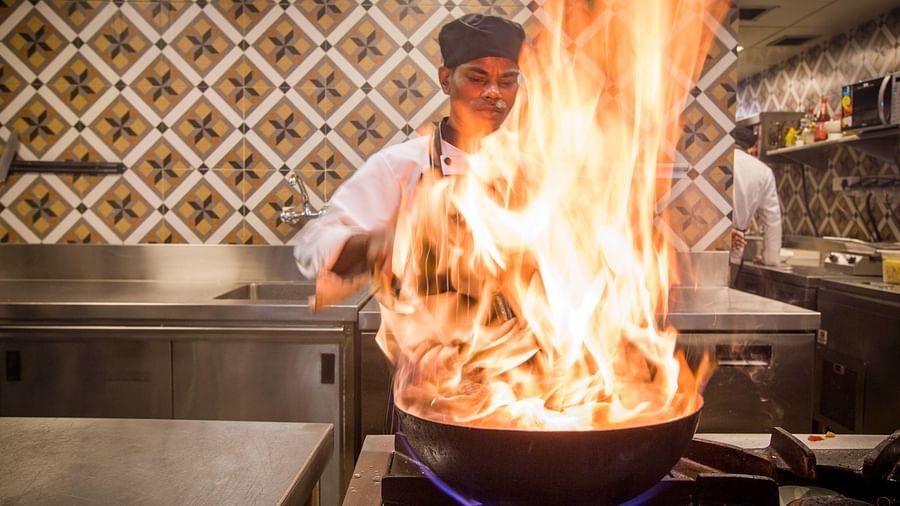 Chef performing a flambe in kitchen at a Lonavala restaurant and bar - Rhythm Lonavala