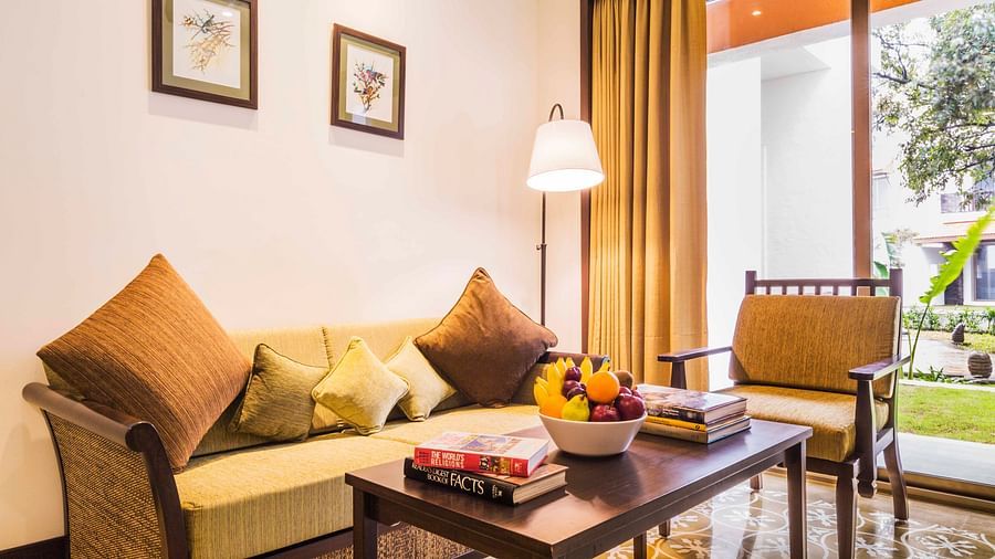 an image of a Couch and chair set around a table inside one of our rooms - Rhythm Lonavala