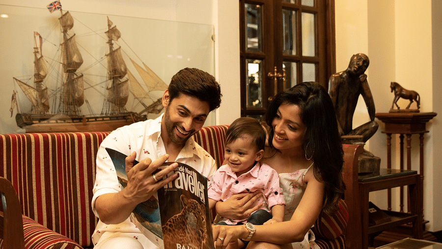 an image of a parents amusing their kid with the Traveller magazine - Rhythm Lonavala