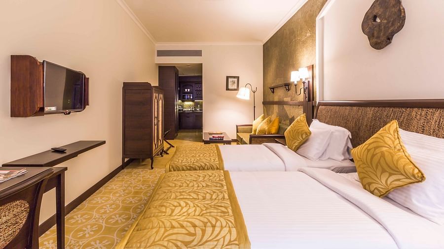 an image of a twin bedroom with gold interiors - Rhythm Lonavala