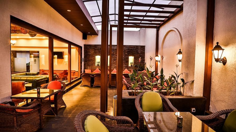 Seating area with wooden chairs and decor - Rhythm Lonavala