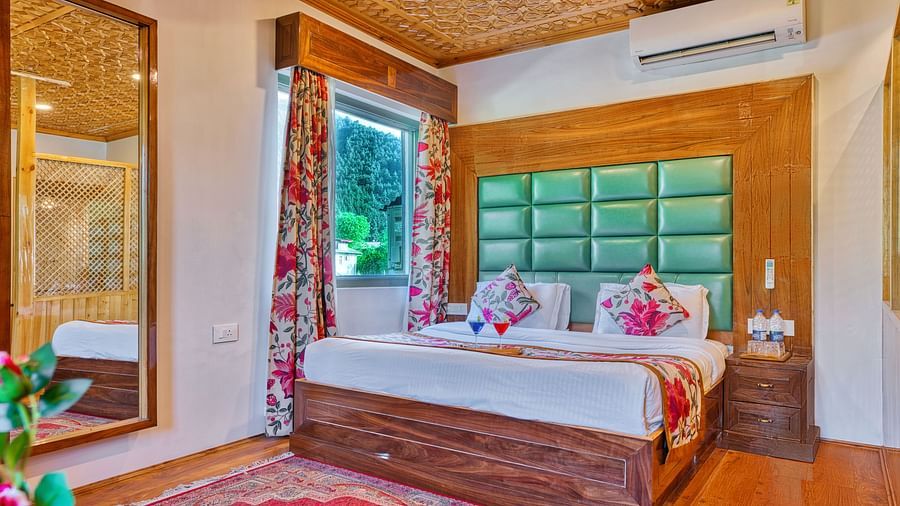 Stylish room with large mirror and window view at Royal Comfort Regency, offering elegance and a homely feel.