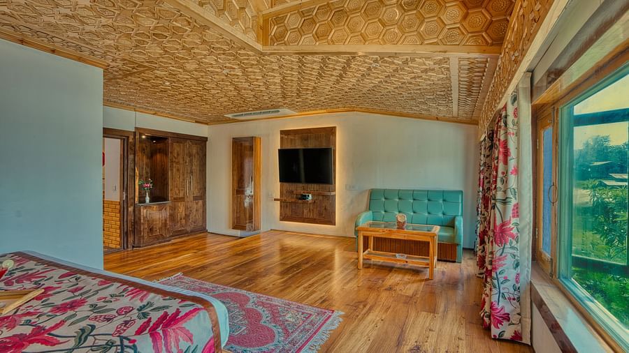 Open suite at Royal Comfort Regency with large windows, warm lighting and elegant wooden interiors for modern comfort.
