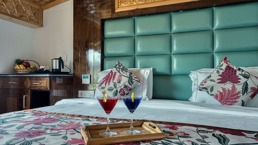 Tastefully designed bedroom with plush green headboard and thoughtful touches at Royal Comfort Regency for a serene stay.