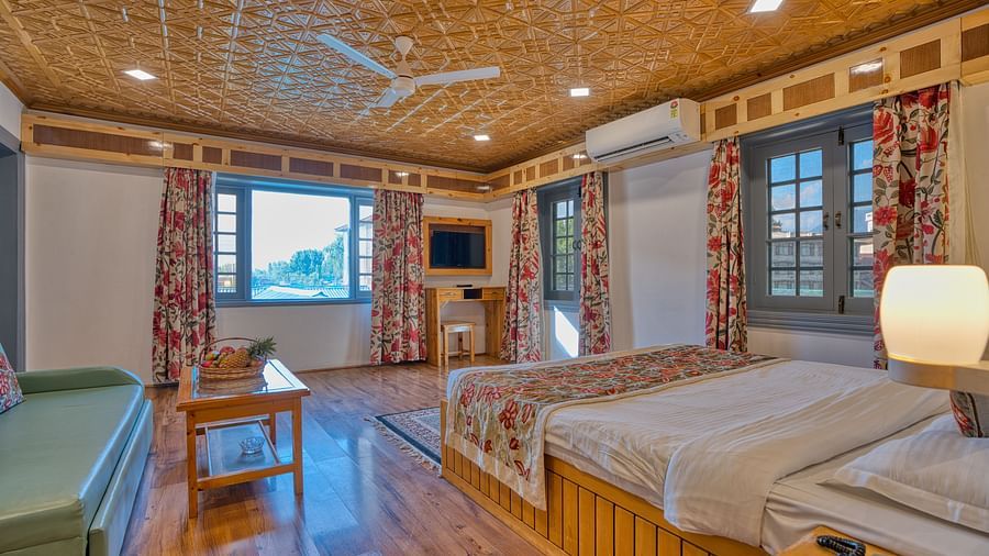 Spacious room with twin beds and modern amenities at Royal Comfort Regency, combining practicality and comfort.