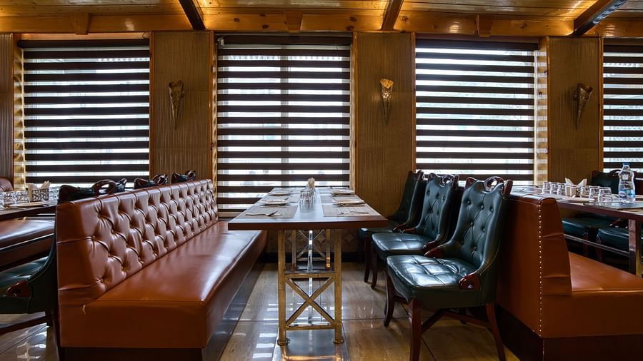 Private booth seating with natural light and modern decor at Royal Comfort Regency, ideal for intimate dining experiences.