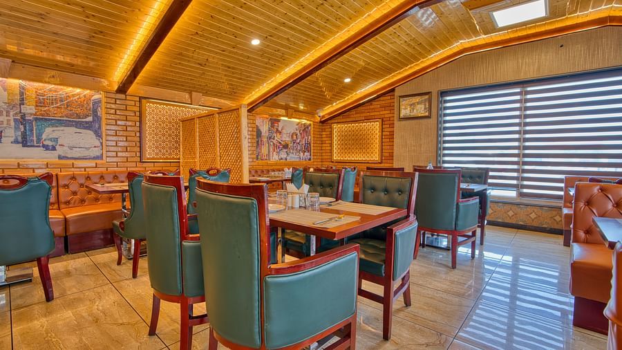 Spacious dining hall at Royal Comfort Regency with elegant furnishings and vibrant lighting, perfect for group or family meals.