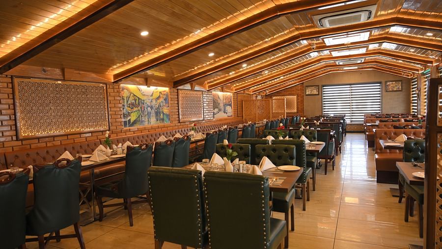 Spacious dining hall with plush seating and ambient lighting at Royal Comfort Regency, ideal for group dining and gatherings.