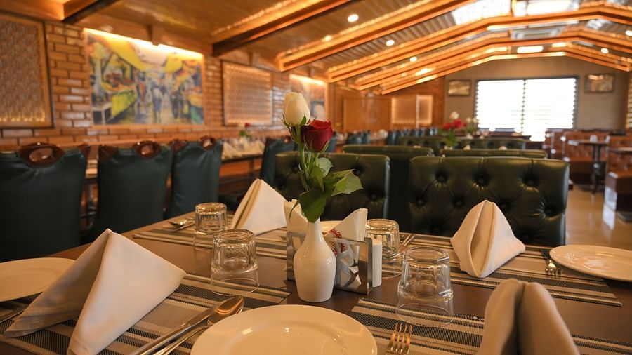 Elegant dining table setup with crisp napkins and warm lighting at Royal Comfort Regency, perfect for a refined dining experience.