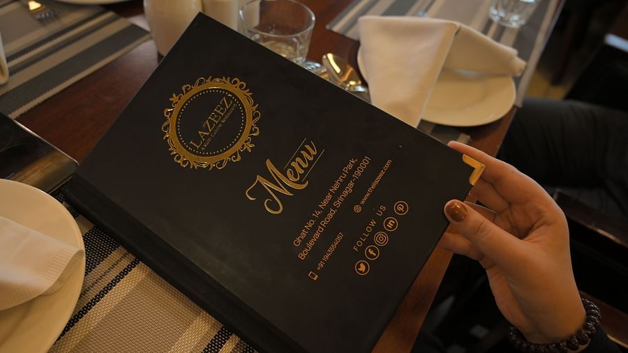 Guest holding the menu at Royal Comfort Regency highlighting a curated selection of dishes for a premium dining experience.