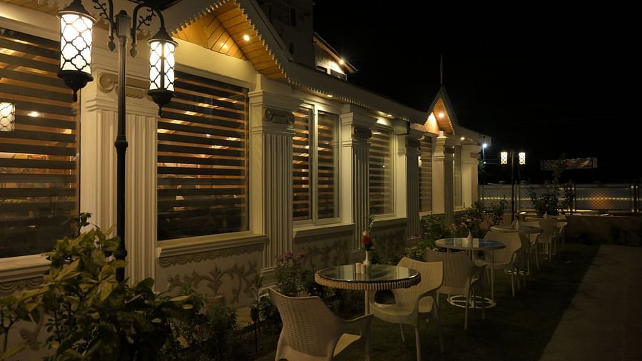 Cosy outdoor seating area at Royal Comfort Regency lit up at night, offering a serene setting for relaxed evening dining.