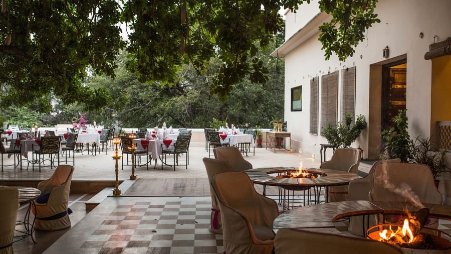 An outdoor patio area at Royal Heritage Haveli with seating around a fire pit and a building in the background.