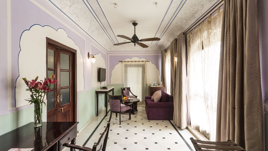  An interior hallway or common area at Royal Heritage Haveli with a patterned floor, seating, and a ceiling fan.