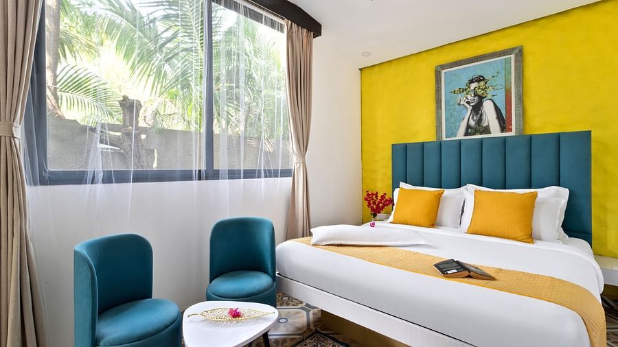 Spacious bedroom with a large window, natural light, and vibrant decor.