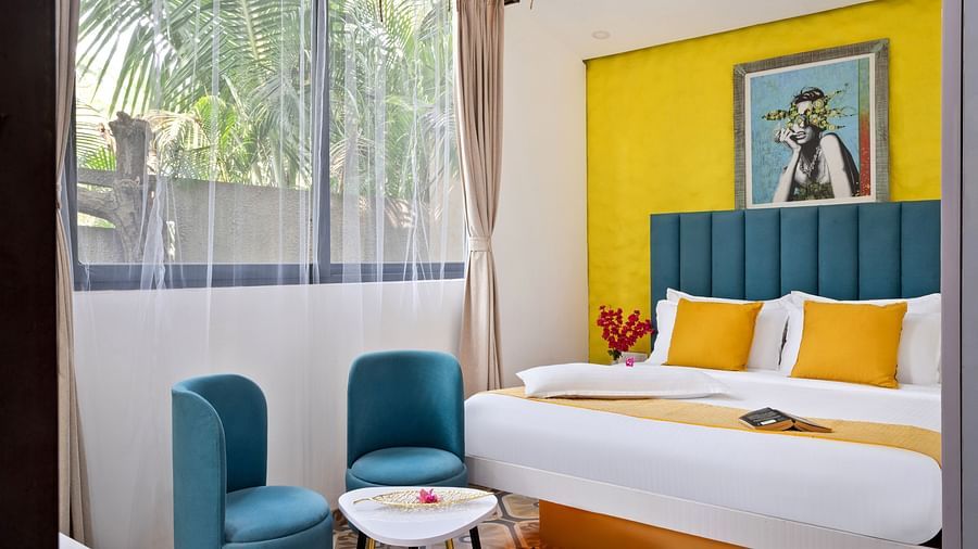 Bedroom featuring artistic decor, bold colours, and a serene outdoor view.
