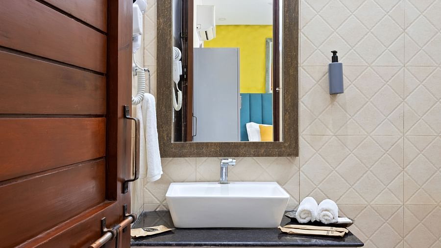 Elegant bathroom with beige tiles, a sleek basin, and fresh white towels.