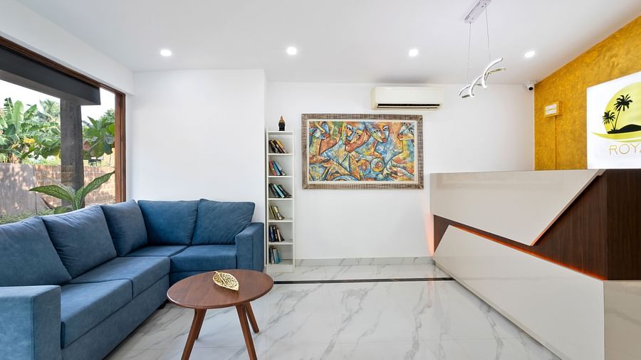 A contemporary living room with a large sofa, a wooden coffee table, and a vibrant painting on the wall.