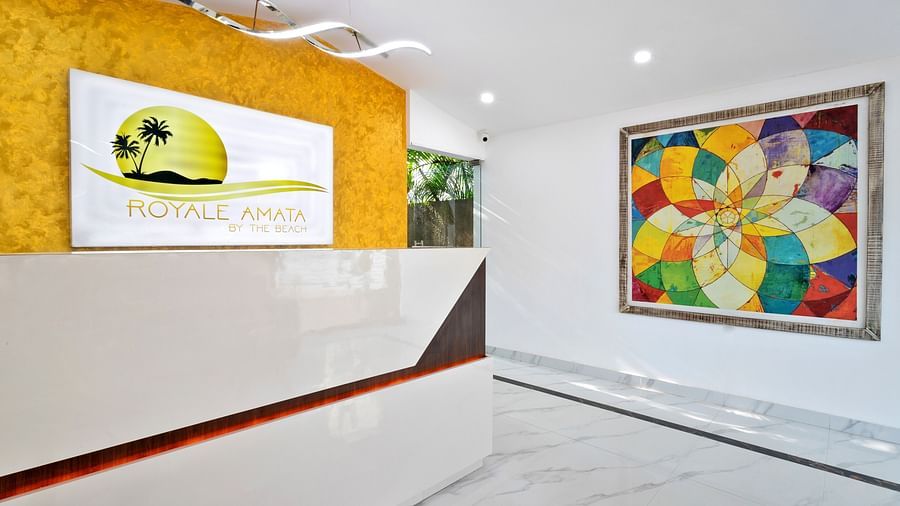 A minimalist reception space with colourful artwork and a clean white-and-yellow design scheme.