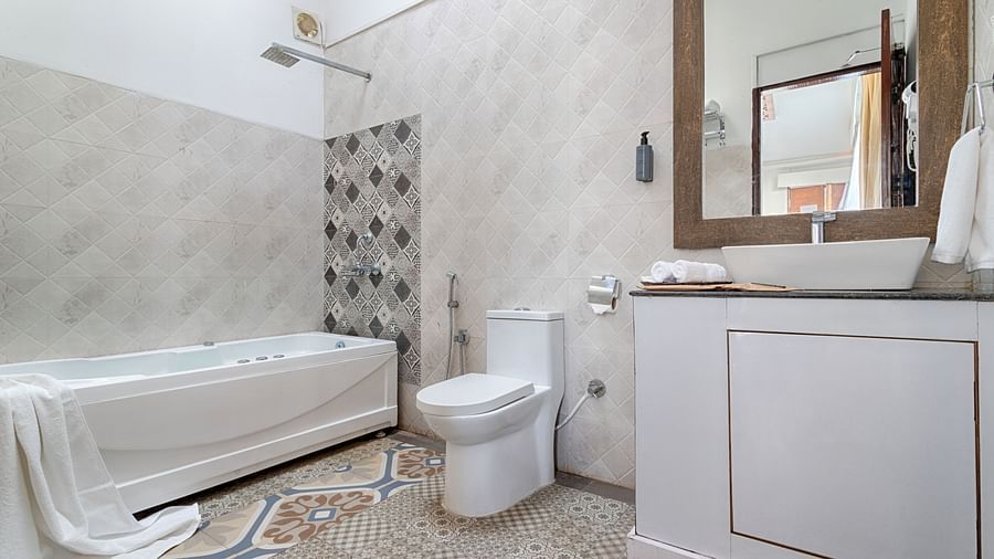 A modern bathroom with a bathtub, a sleek white vanity, and patterned tiles.