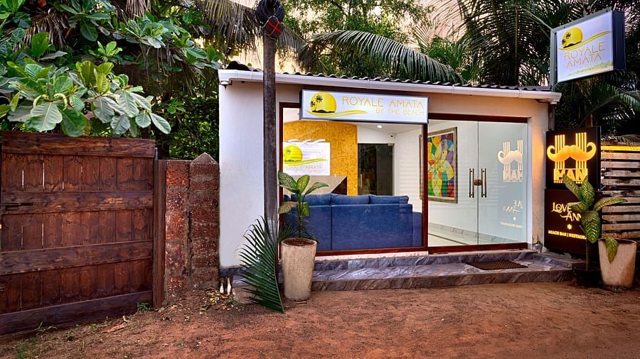 A peaceful courtyard with lush greenery and a wooden entrance.