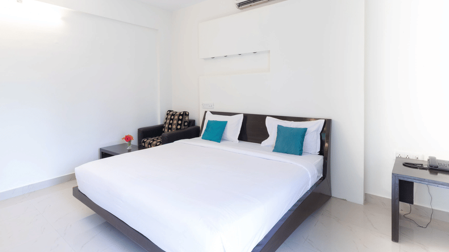 Clean and well-lit standard room with double bed at Sanctum Suites Domlur Bangalore
