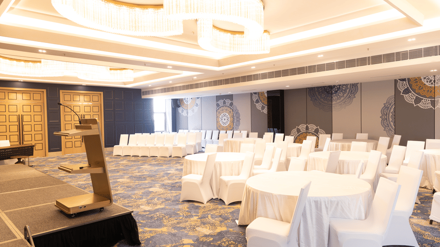 Bright workshop room featuring 3 circular tables and a whiteboard at Sands Point Hotel, Pondicherry.