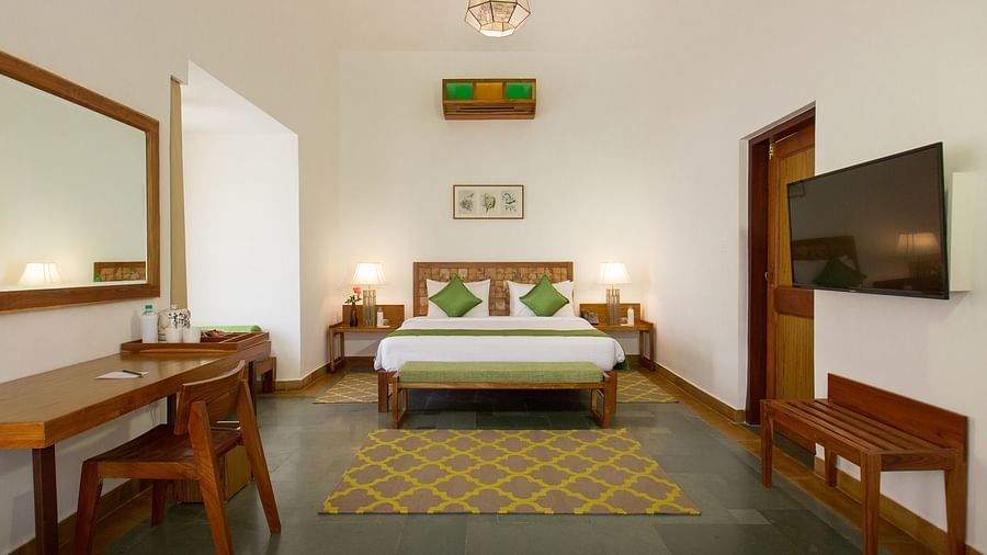 A room at Saraca Resort & Spa Corbett with a double bed, a television and a work desk and chair
