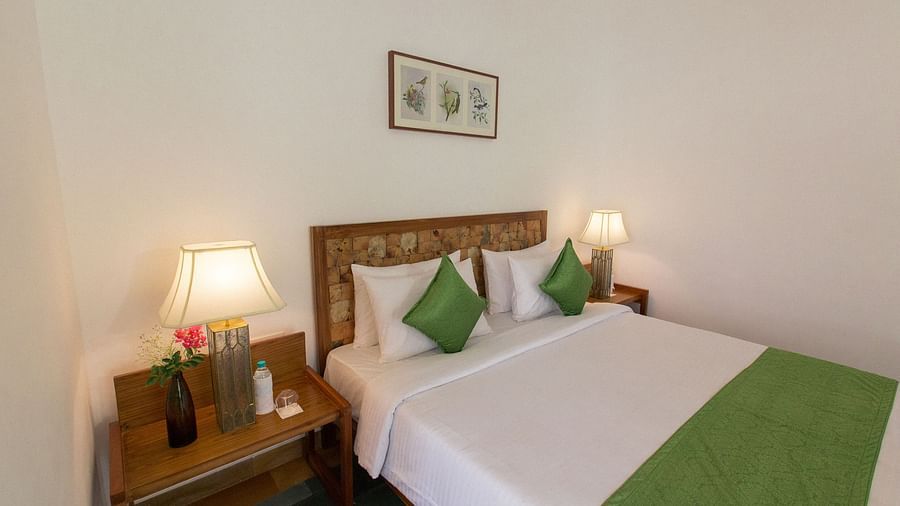 A room at Saraca Resort & Spa Corbett with a double bed and side tables with bed lamps placed on top of them