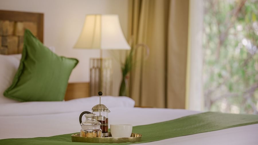 A tray with coffee placed on the bed in a room at Saraca Resort & Spa Corbett