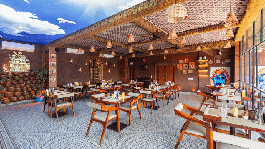 Spacious restaurant dining area featuring wooden lattice ceiling, fans, and numerous set tables.
