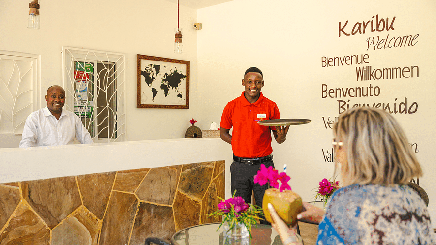 Staff at shooting star lodge welcoming a guest with cocount water in the reception