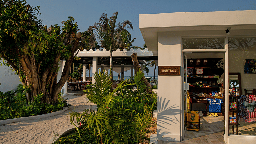 A charming boutique shop with an open entrance, surrounded by lush greenery and tropical plants at Shooting Star Boutique Hotel