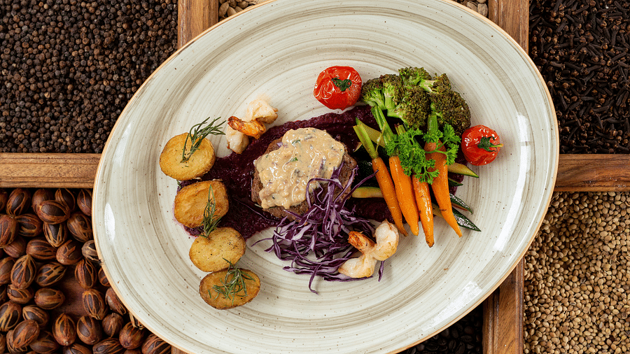 A plated dish with a protein, roasted vegetables, and a side of purple puree, elegantly arranged at Shooting Star Boutique Hotel