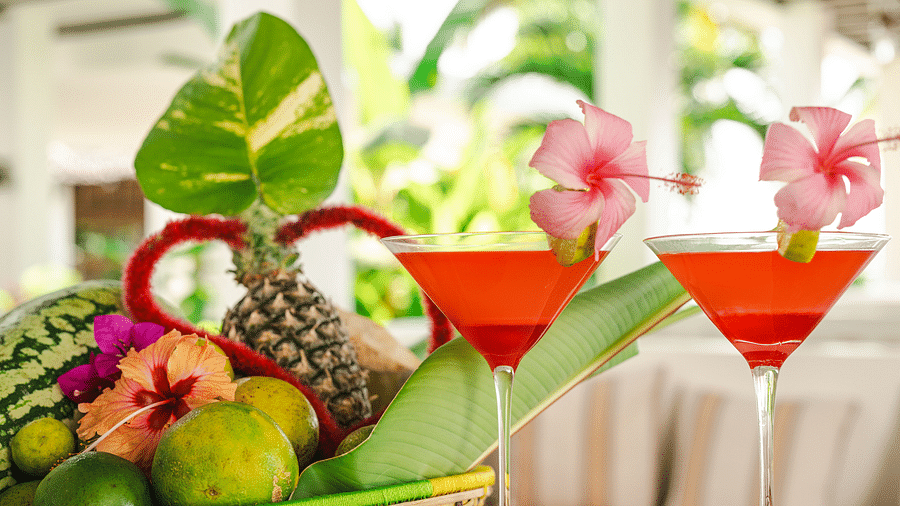 A vibrant basket of tropical fruits with elegantly garnished cocktails at SHooting star Boutique Hotel