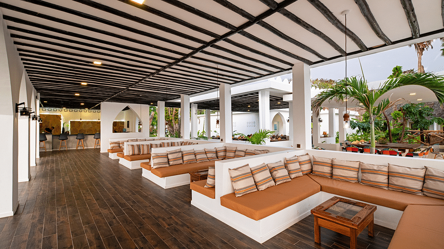 Spacious open-air lounge area with wooden flooring, plush seating, and arched openings overlooking tropical greenery - Shooting Star Boutique Hotel.