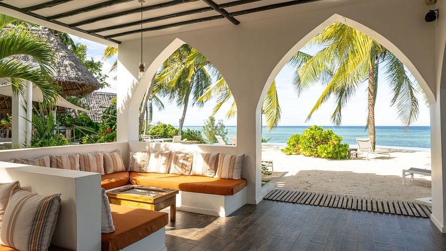 Cosy lounge area with a sea view framed by arched doorways, featuring warm-toned cushions and wooden furniture - Shooting Star Boutique Hotel.