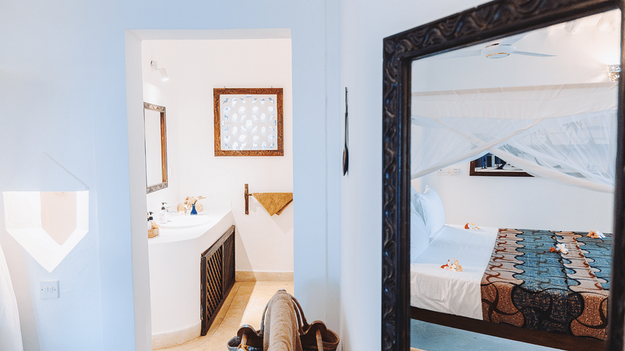 View of the room with a bed and a doorway with a peak of the bathroom can be seen in the background - Shooting Star Boutique Hotel.