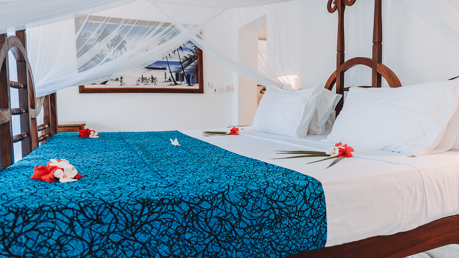 Side view of a bed with photo frame on the wall in the background in Sea View Family Cottages - Shooting Star Boutique Hotel.