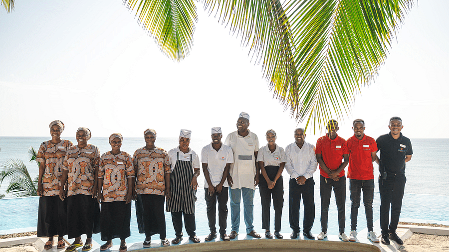 Staff members at shooting star Boutique Hotel posing for a group picture with swimming pool in the background