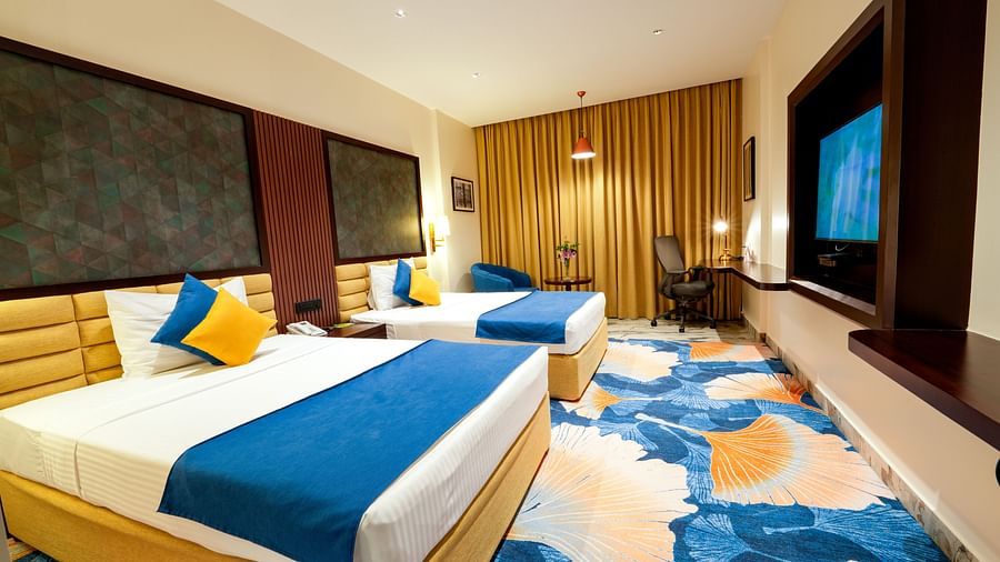 Room at Sitara Luxury Hotel in Hyderabad near Ramoji Film City with twin beds and a television