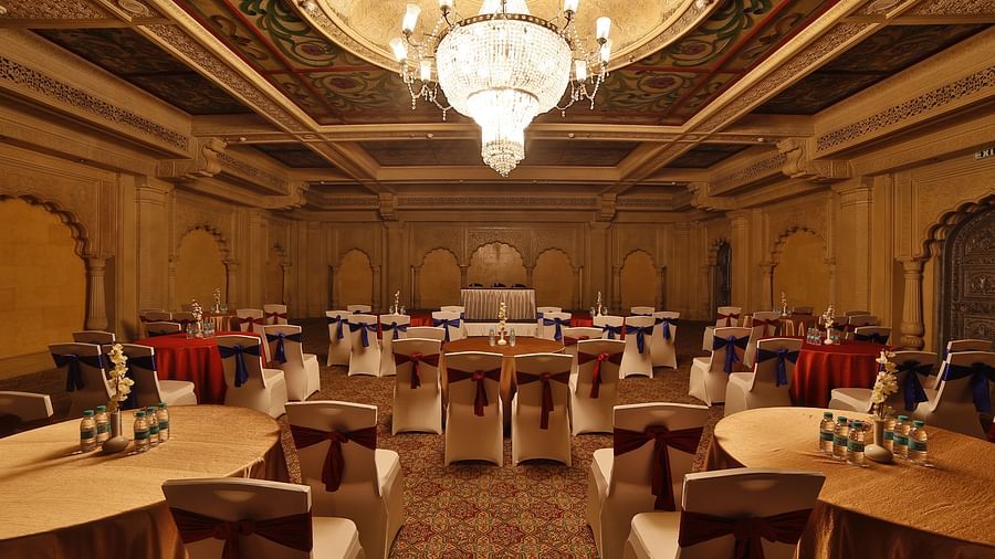 Seating arrangement in Taj Mahal Hall A grand hotel suite with an opulent red and white decor, large bed, and seating area, reflecting a traditional style at Sitara Luxury Hotel in Hyderabad near Ramoji Film City.