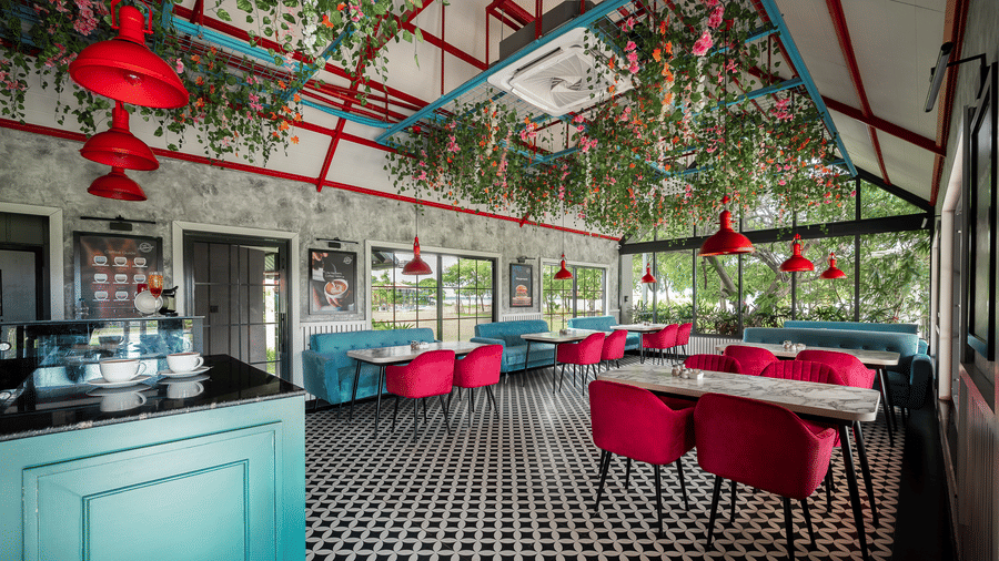 Restaurant interior with chairs, booth seating, a patterned tiled floor, and hanging decorations from the ceiling at Hotel Sonar Bangla, Taki.