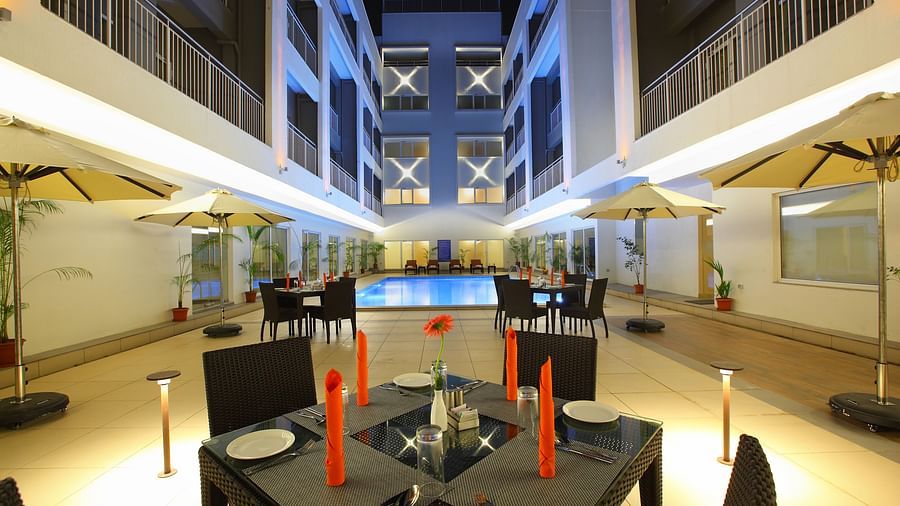 A close up shot of the dining table next to the Pool in the evening - Starlit Suites, Kochi