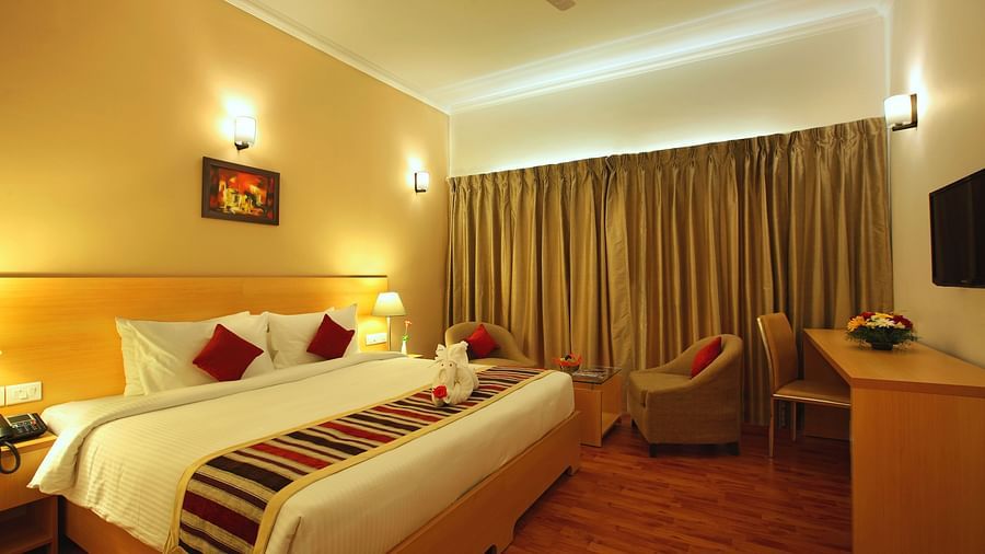 A king bed with side tables and lamps inside Premium Room - Starlit Suites, Kochi