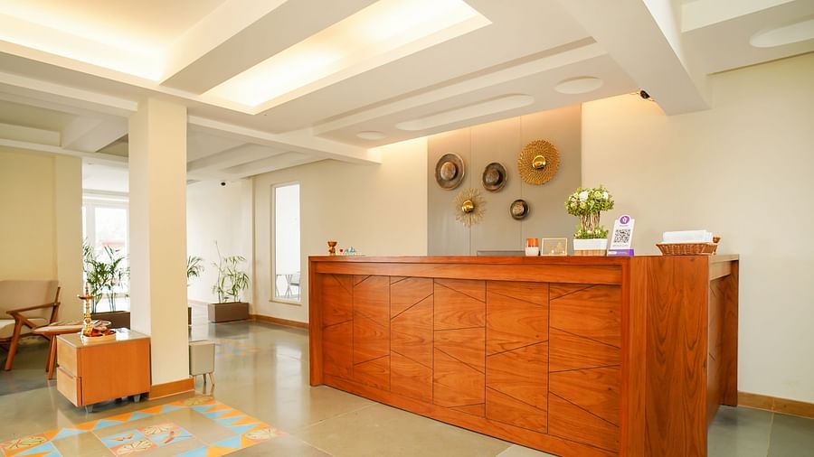 A spacious hotel lobby with a prominent wooden reception desk and a clear view of the open layout | Sukama Resort & Spa, Nainital