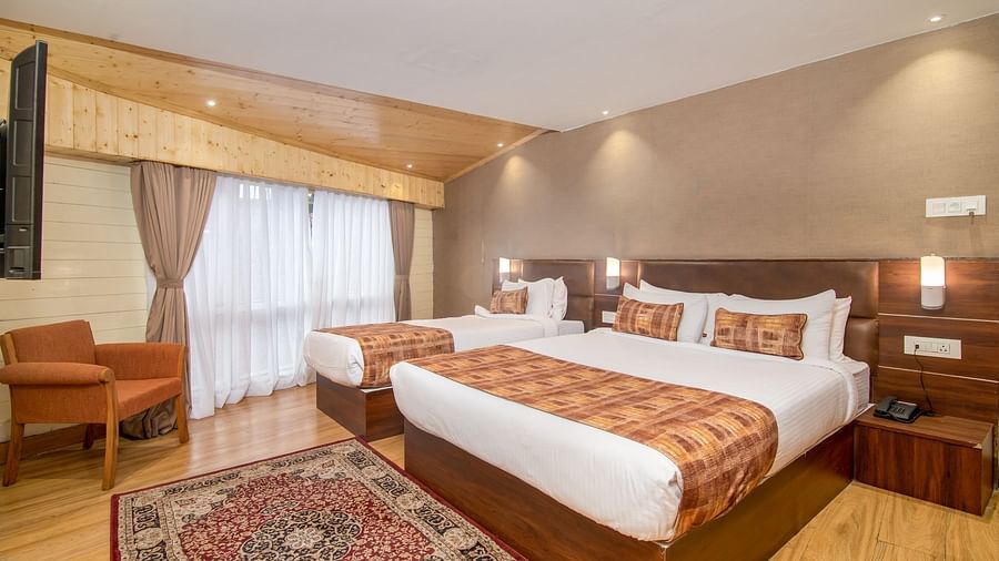 An image of a room with a queen size bed and a single bed with TV and minimal decoration - Sumitel Vista TV Tower