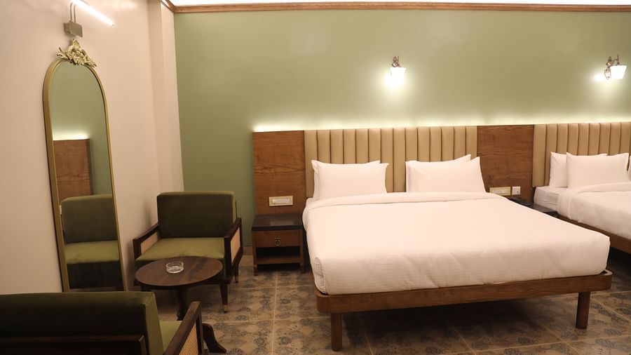 two double beds, a seating area and a mirror in one of the Heritage Suites at Summer House, Nandi Hills